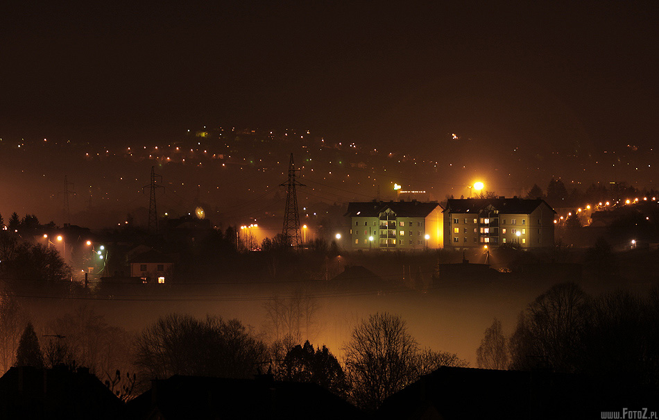 Mglisty nocny widok - widok na miasto, mglista dolina, domy nocą na wzgórzu